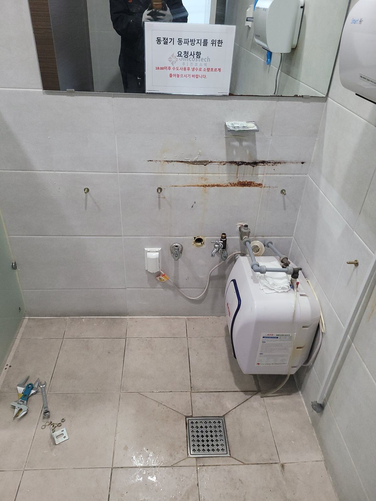 세면대 철거 후 벽면에 남은 녹슨 고정 볼트